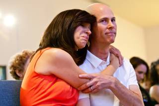 Karen Turnbull embraces her husband, Mike Turnbull, a trombonist who is recovering from stage-four thyroid cancer, during a musical fundraiser to help them with medical bills held at New Song Anthem Church Saturday, May 12, 2013.